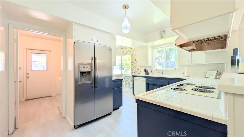 1418 Niagara Avenue Claremont, CA 91711 - Photo 13 of 29 a kitchen with stainless steel appliances kitchen island granite countertop a refrigerator a sink dishwasher with a dining table and chairs