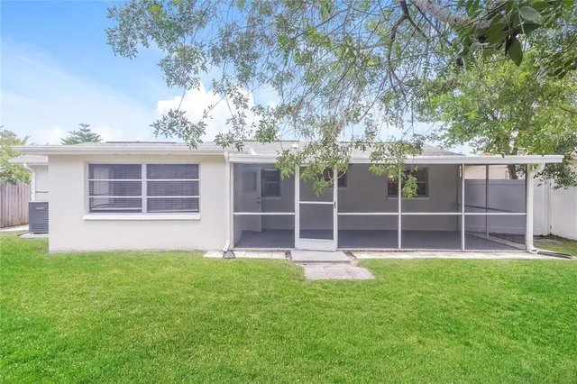 a view of a house with a yard and a large tree