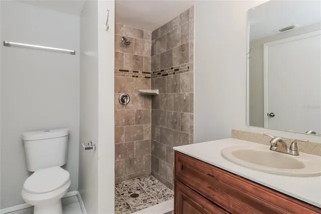 an empty room with wooden floor and ceiling fan