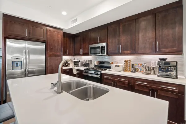 a kitchen with granite countertop a refrigerator and a stove top oven