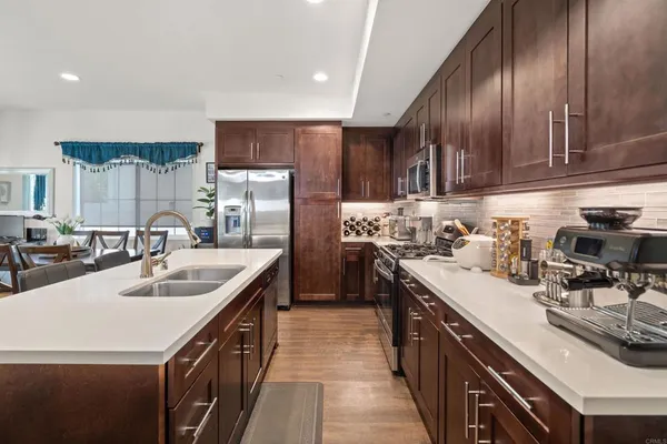 a kitchen with stainless steel appliances granite countertop a sink stove and refrigerator