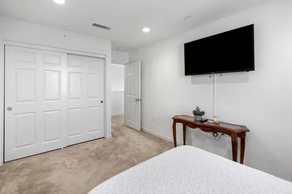 a bedroom with a bed and a flat screen tv