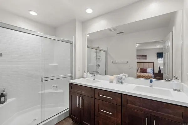 a bathroom with a double vanity sink mirror double and shower