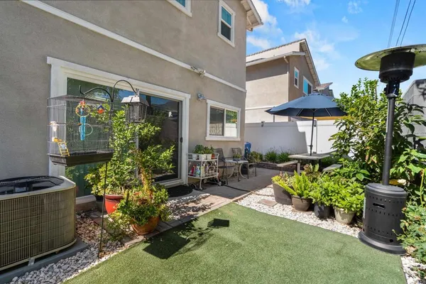 a view of a backyard with chair and potted plants
