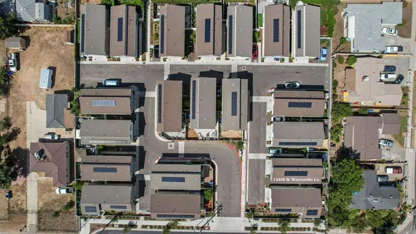 an aerial view of residential house and sandy dunes