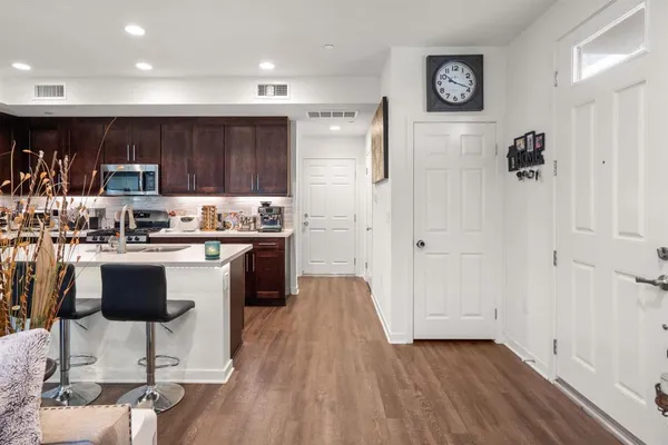 a kitchen with kitchen island granite countertop wooden floors and white cabinets