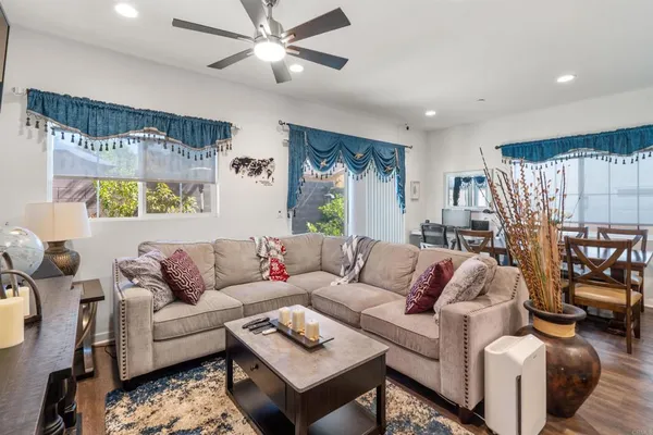 a living room with furniture ceiling fan and a wooden floor