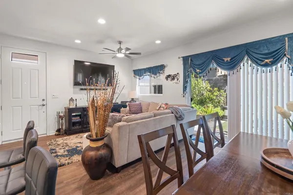 a living room with furniture a flat screen tv and a floor to ceiling window