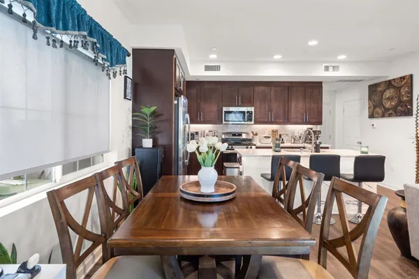 a view of a dining room with furniture a kitchen and chandelier
