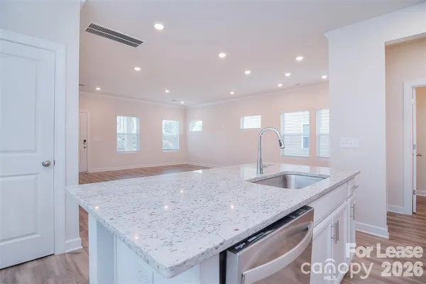 a kitchen with center island a sink and a wooden floor