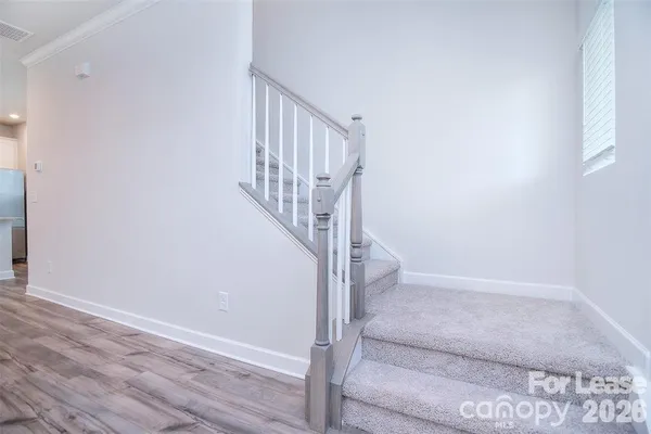 a view of staircase with white walls and white door