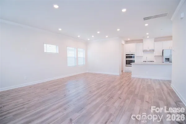 a view of large kitchen with wooden floor and windows