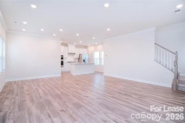a view of a kitchen with wooden floor and a window
