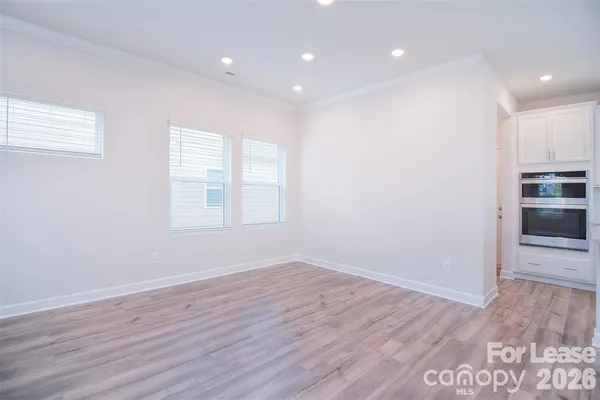 a view of empty room with wooden floor and window
