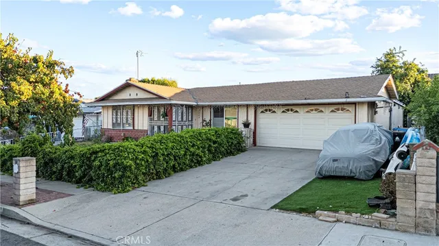 a view of a house with a backyard and plants