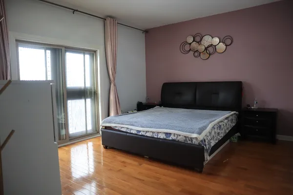 a bedroom with a bed and wooden floor