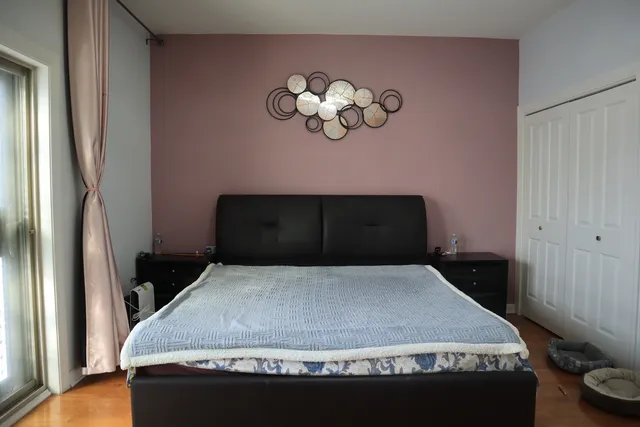 a bedroom with a bed and a wall painting