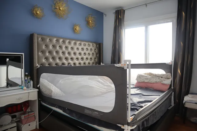 a bed sitting in a bedroom next to a window