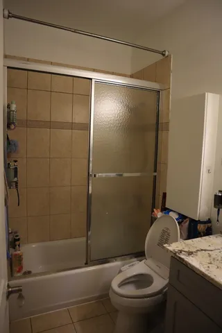 a bathroom with a granite countertop toilet sink and shower