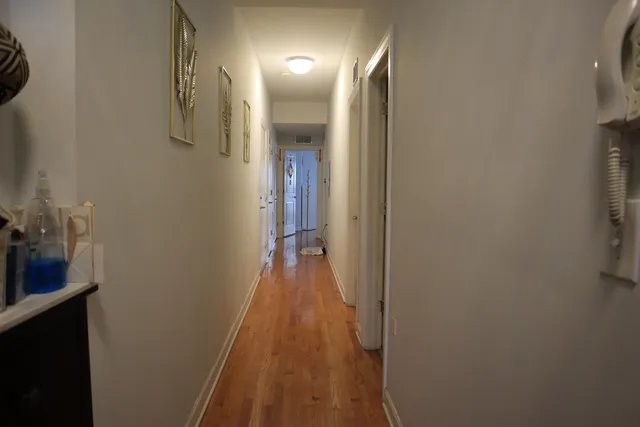 a view of a hallway with wooden floor