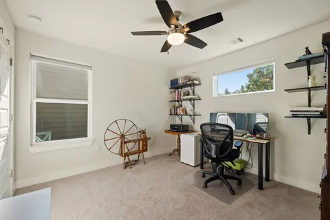 a view of a workspace with furniture and a ceiling fan