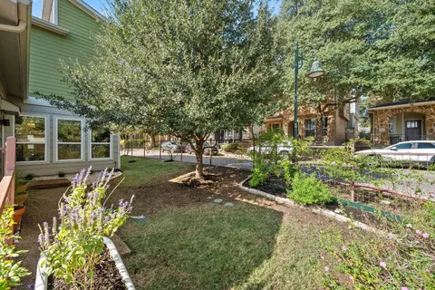 a view of a house with a large tree and a yard