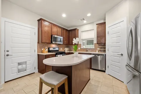 a kitchen with stainless steel appliances a refrigerator sink and stove