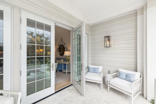 a living room with furniture a large window and a chandelier