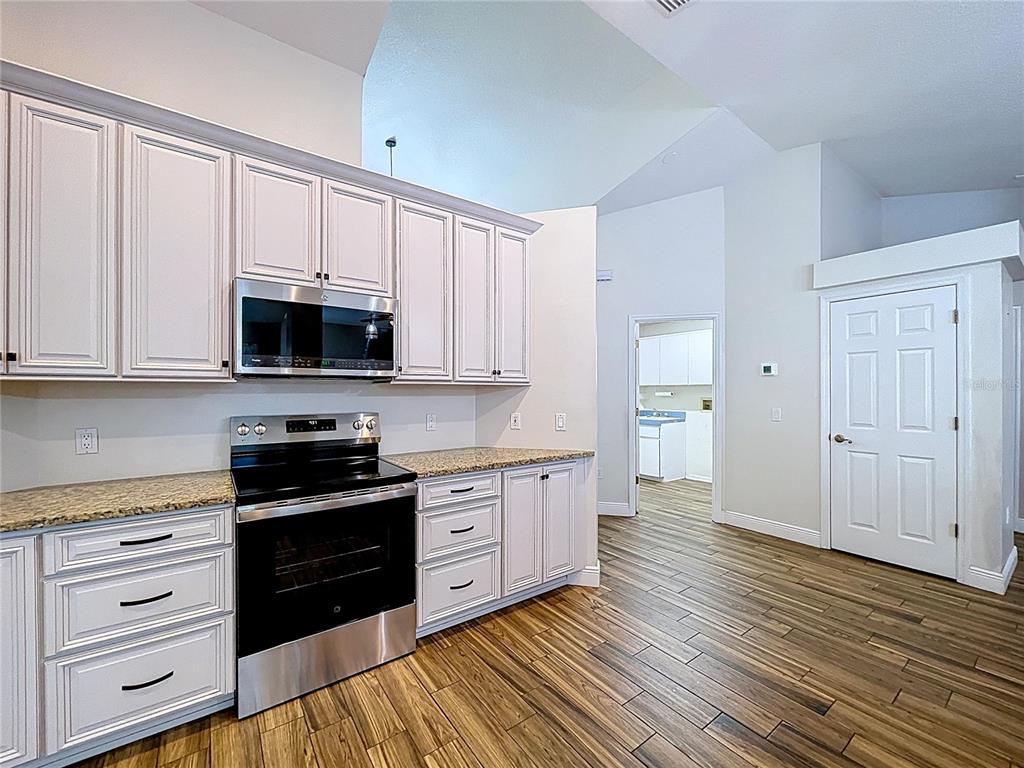 18812 Bascomb Lane Hudson, FL 34667 - Photo 33 of 57 a kitchen with stainless steel appliances granite countertop a stove and a microwave
