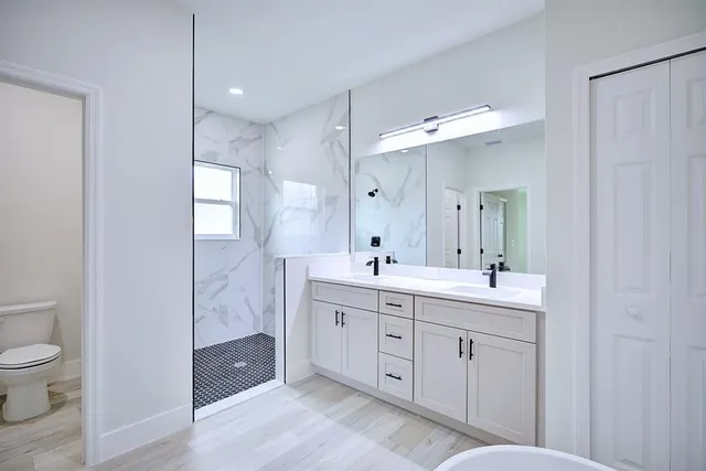 a spacious bathroom with a toilet sink and mirror