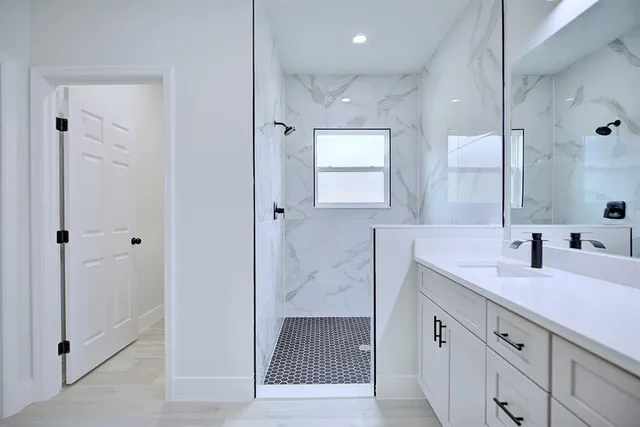 a bathroom with a shower sink and mirror