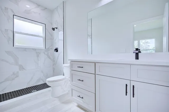 a bathroom with a sink toilet and shower