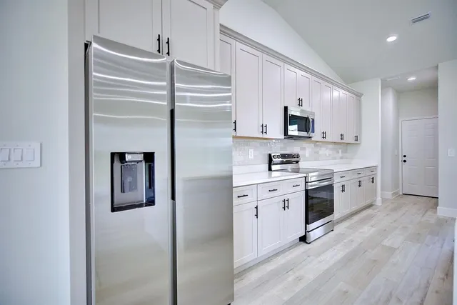 a kitchen with stainless steel appliances a refrigerator sink and microwave