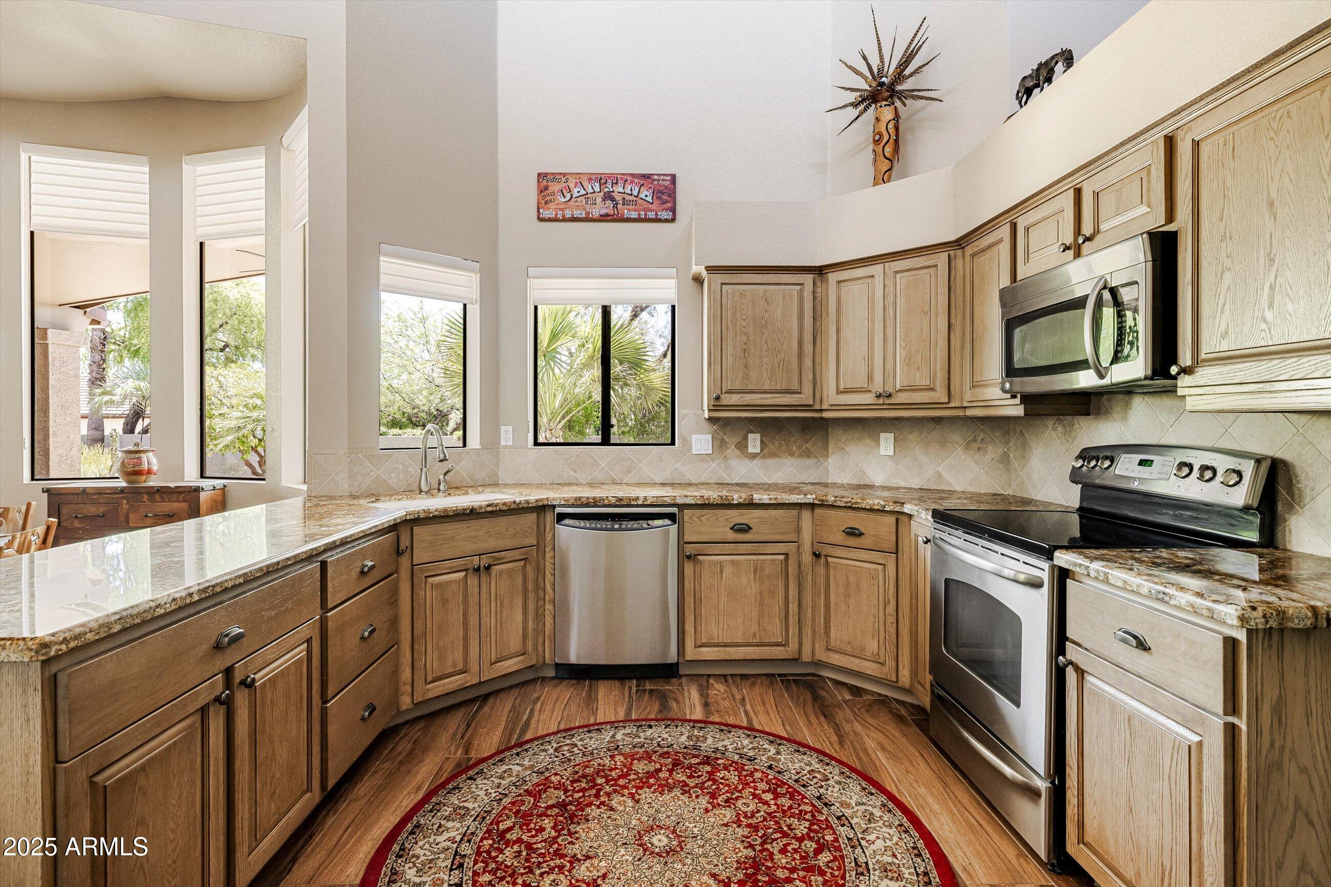 25821 North Bolero Bend Rio Verde, AZ 85263 - Photo 15 of 42 a kitchen with stainless steel appliances granite countertop a stove sink and cabinets