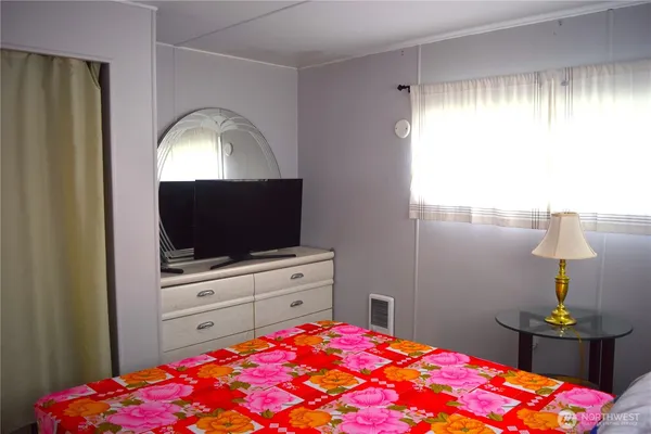 a bedroom with a bed and a flat screen tv