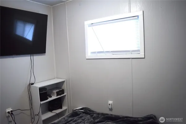 a room with a flat screen tv and a window