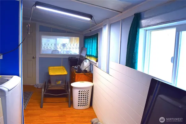 a living room with furniture a flat screen tv and floor to ceiling window