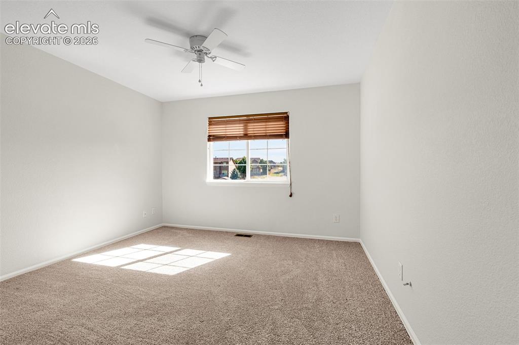 11185 Falling Star Road Fountain, CO 80817 - Photo 17 of 46 an empty room with windows and ceiling fan