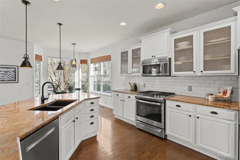 a kitchen with stainless steel appliances granite countertop a sink stove and microwave