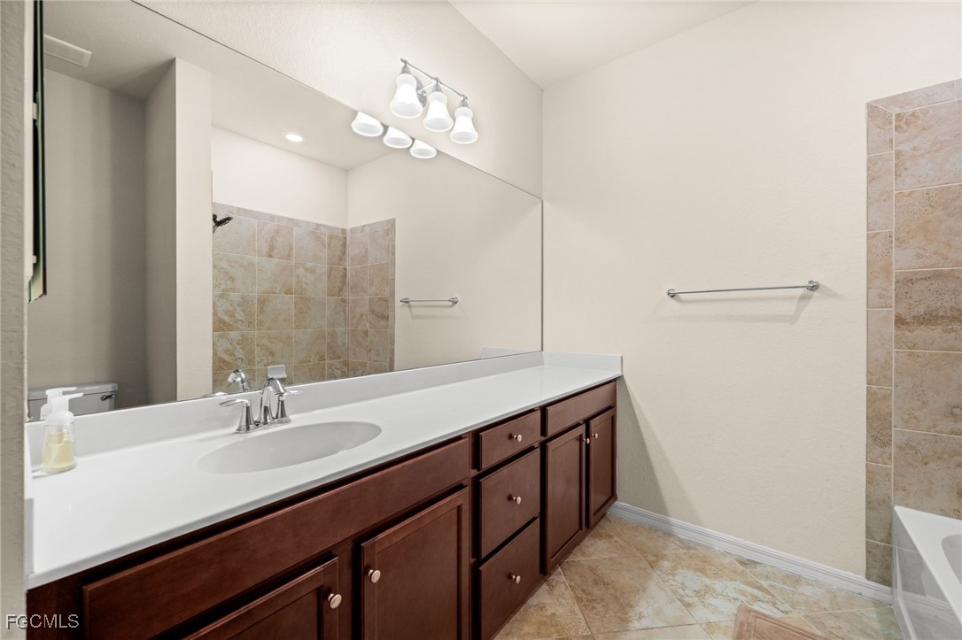 10173 Via Colomba Circle Fort Myers, FL 33966 - Photo 30 of 50 a bathroom with a double vanity sink a and a mirror