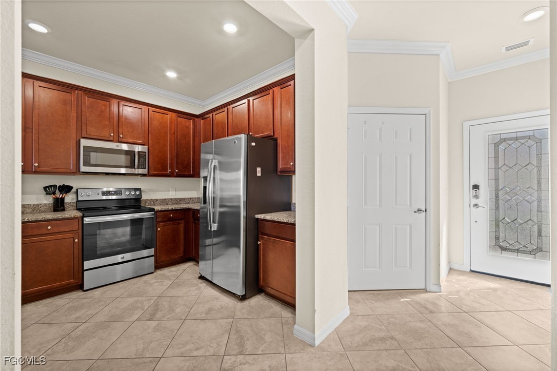 10173 Via Colomba Circle Fort Myers, FL 33966 - Photo 7 of 50 a kitchen with stainless steel appliances granite countertop a refrigerator and a stove
