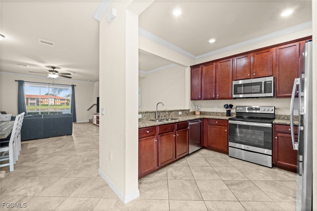 10173 Via Colomba Circle Fort Myers, FL 33966 - Photo 8 of 50 a kitchen with stainless steel appliances granite countertop a stove refrigerator and microwave