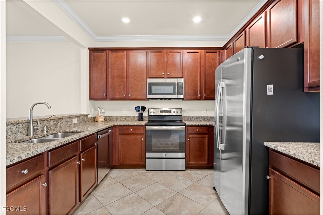 10173 Via Colomba Circle Fort Myers, FL 33966 - Photo 9 of 50 a kitchen with stainless steel appliances granite countertop a refrigerator sink and stove