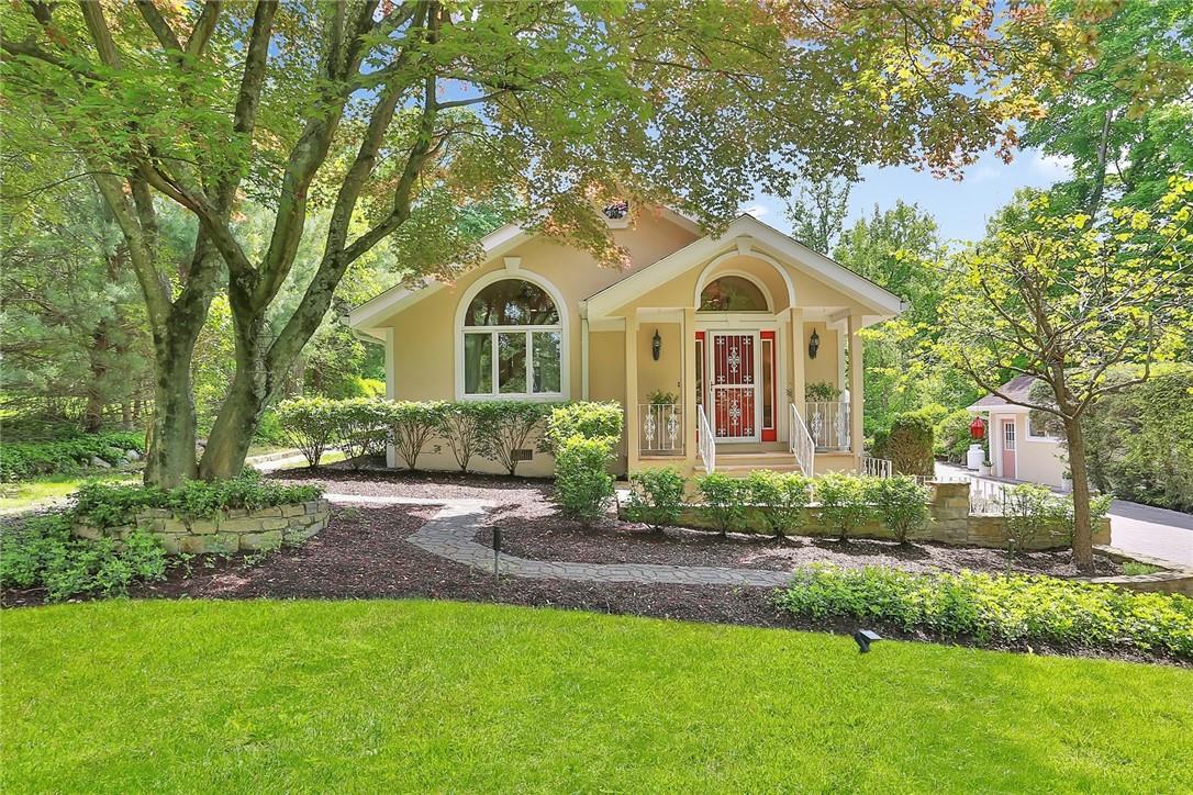 a front view of a house with yard and green space
