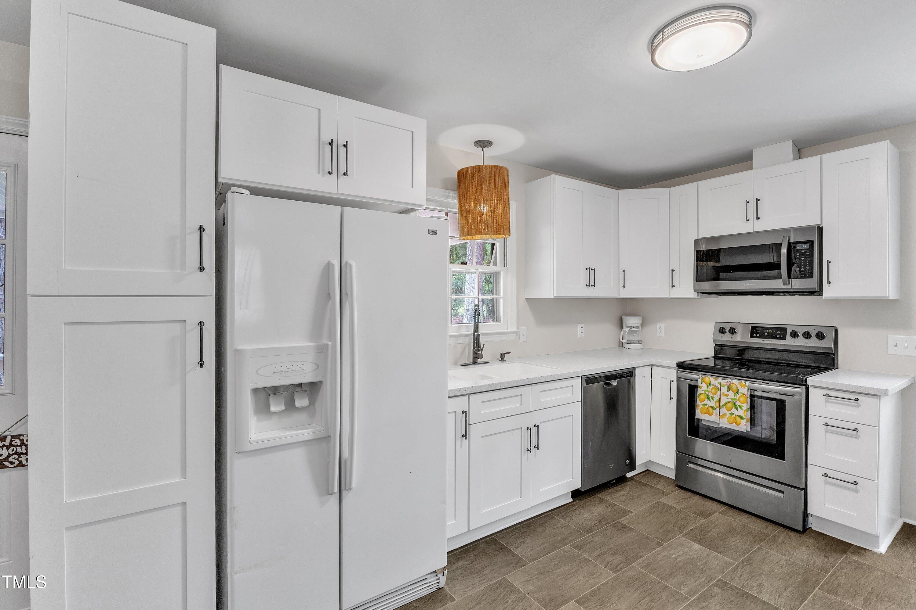 1703 Cranston Road Garner, NC 27529 - Photo 12 of 35 a kitchen with white cabinets and white appliances