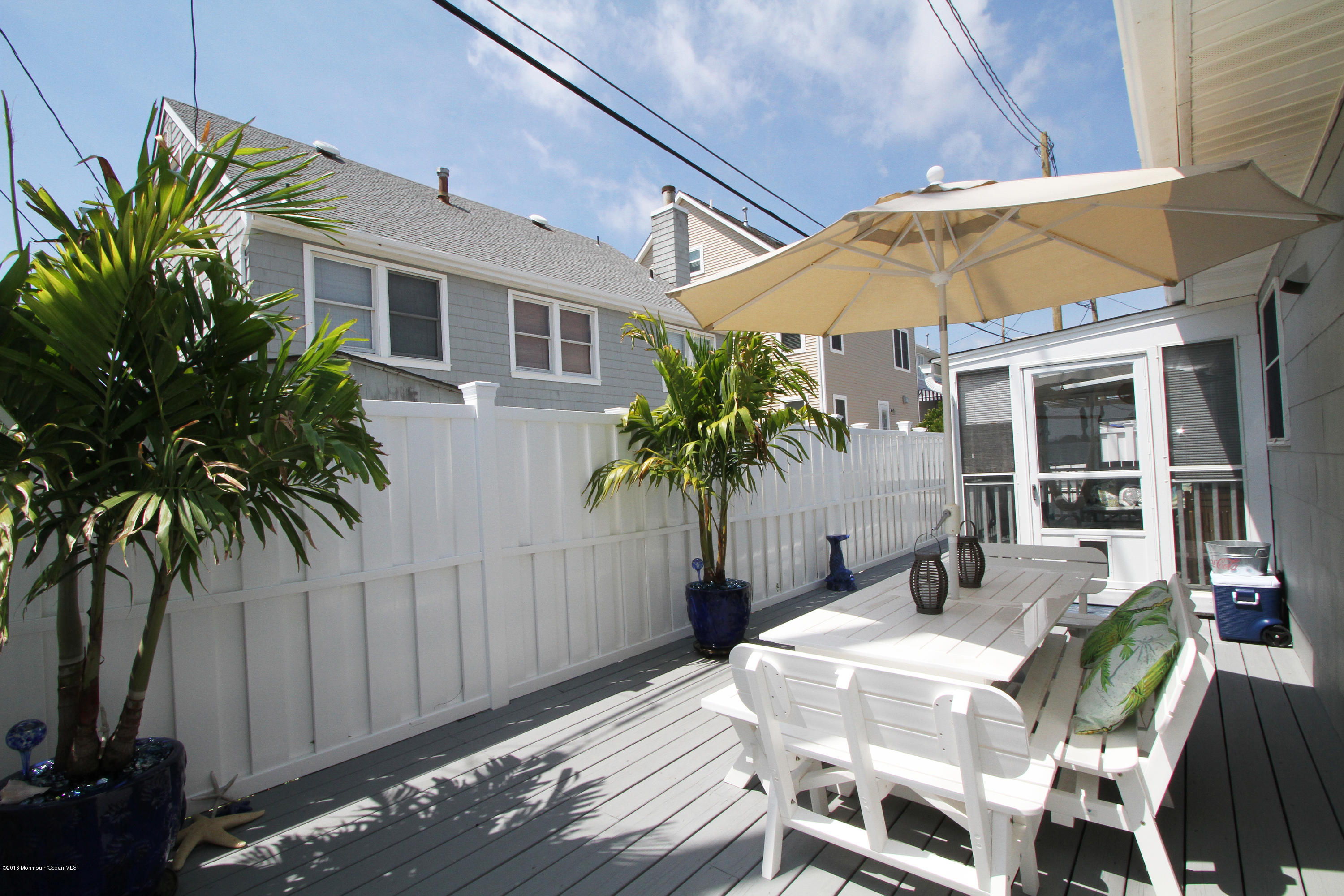 37 Silver Beach Road Lavallette, NJ 08735 - Photo 18 of 33 a patio with a table and chairs under an umbrella