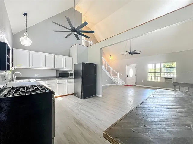 a kitchen with granite countertop a stove cabinets and wooden floor