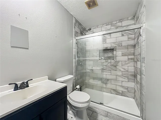 a bathroom with a bathtub shower sink mirror and toilet