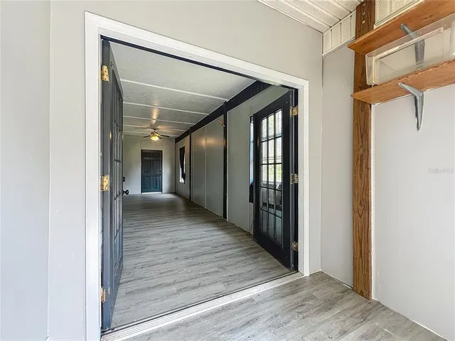 a view of a hallway with wooden floor and staircase