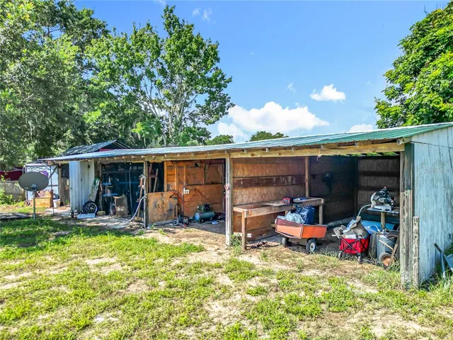 a view of a chair and table in backyard of the house